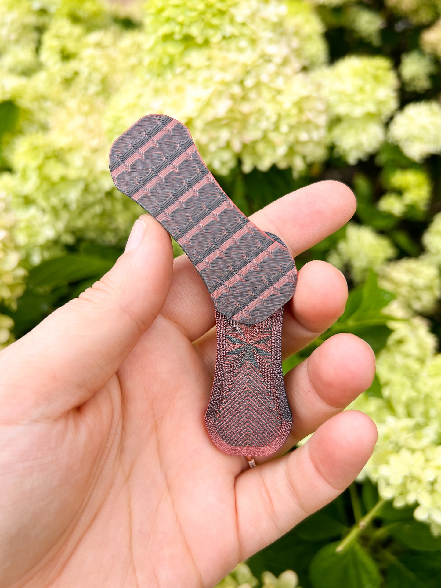 Black and red magnetic fidget slider in hand floral background