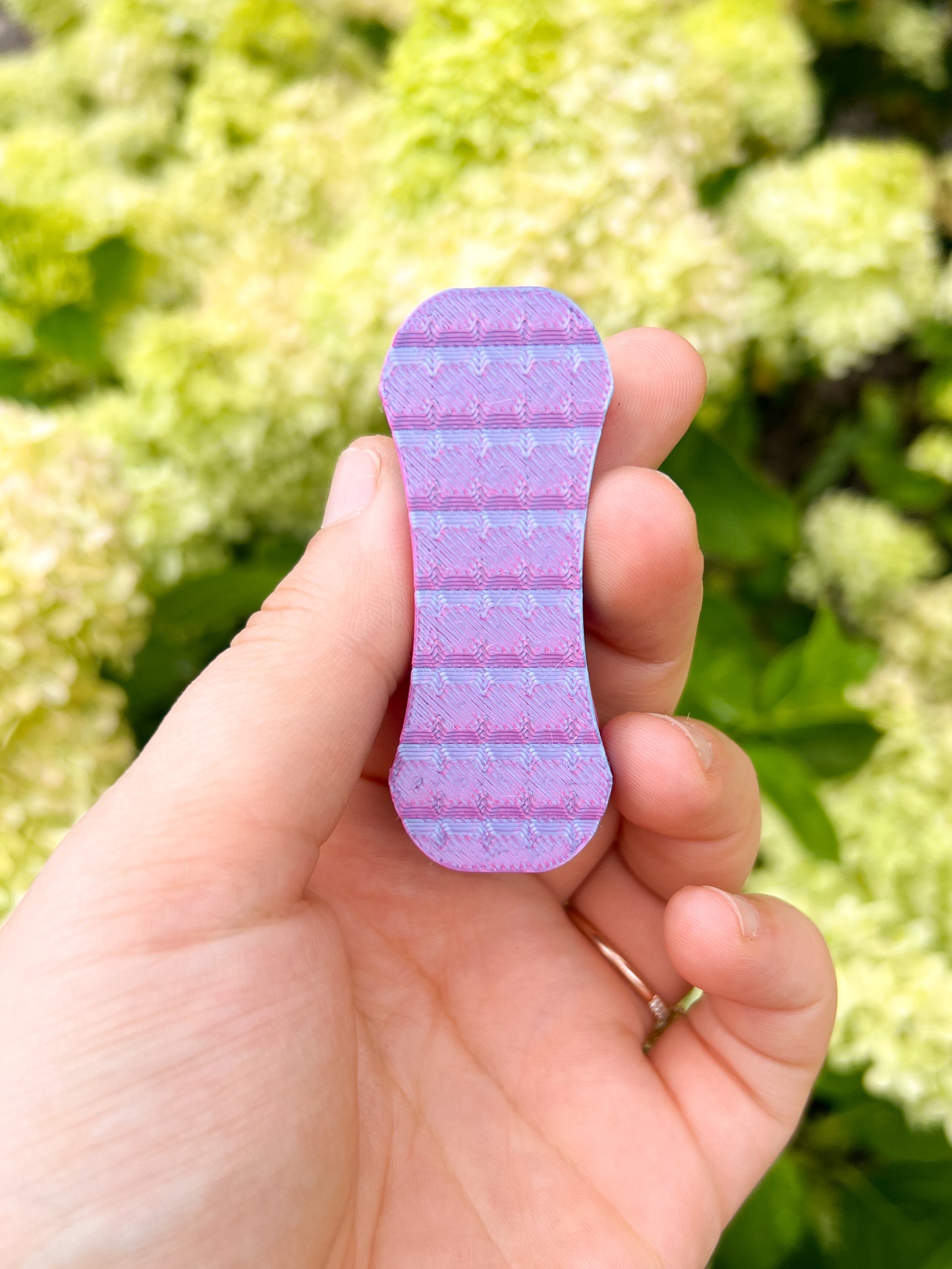 Pink and purple magnetic fidget slider in hand floral background