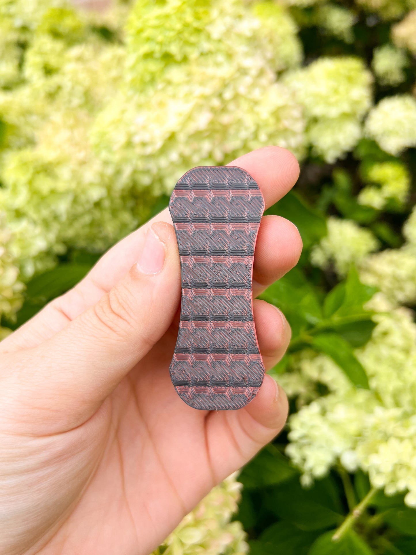 Black and red magnetic fidget slider in hand floral background