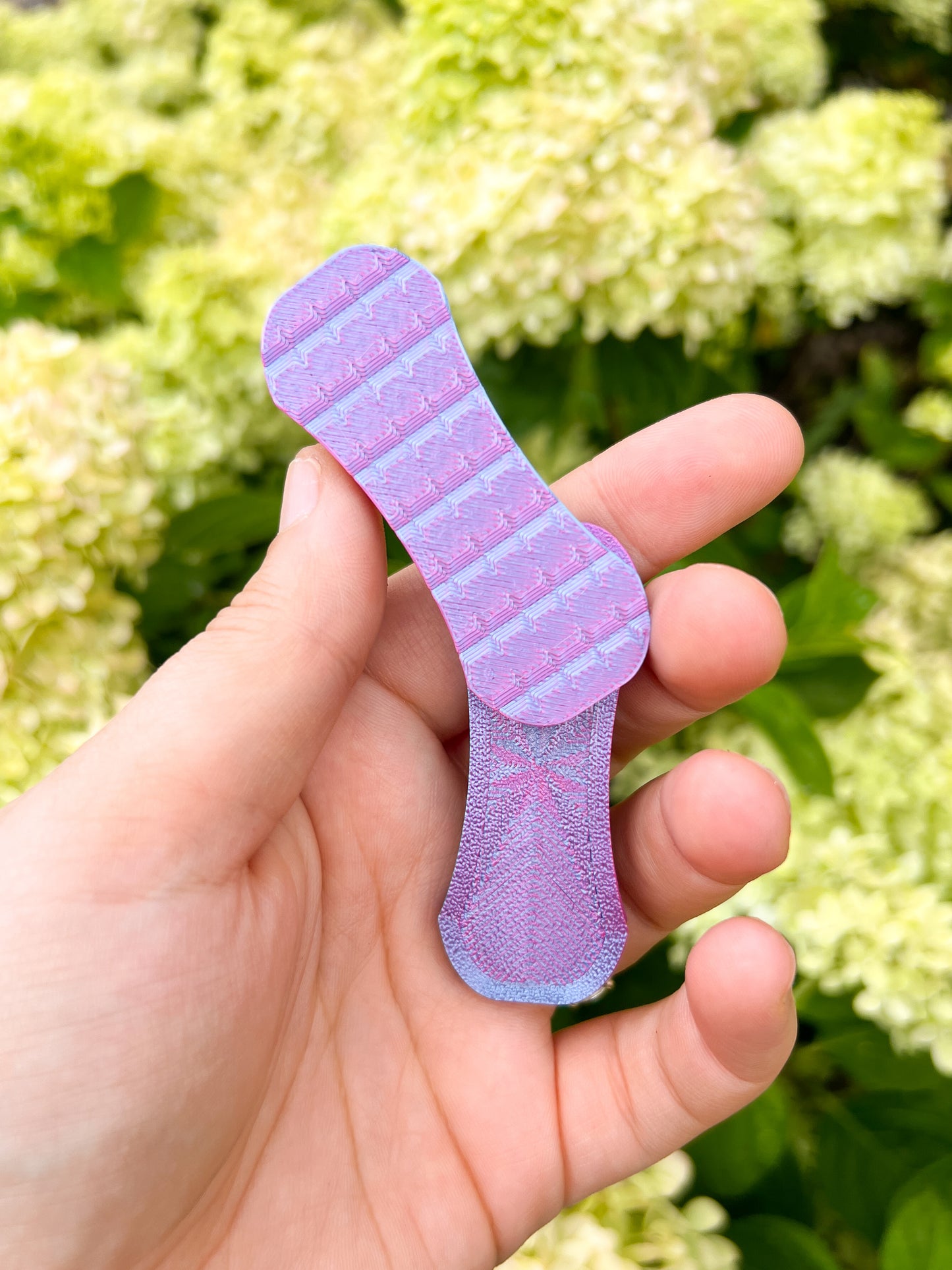 Pink and purple magnetic fidget slider top view in hand