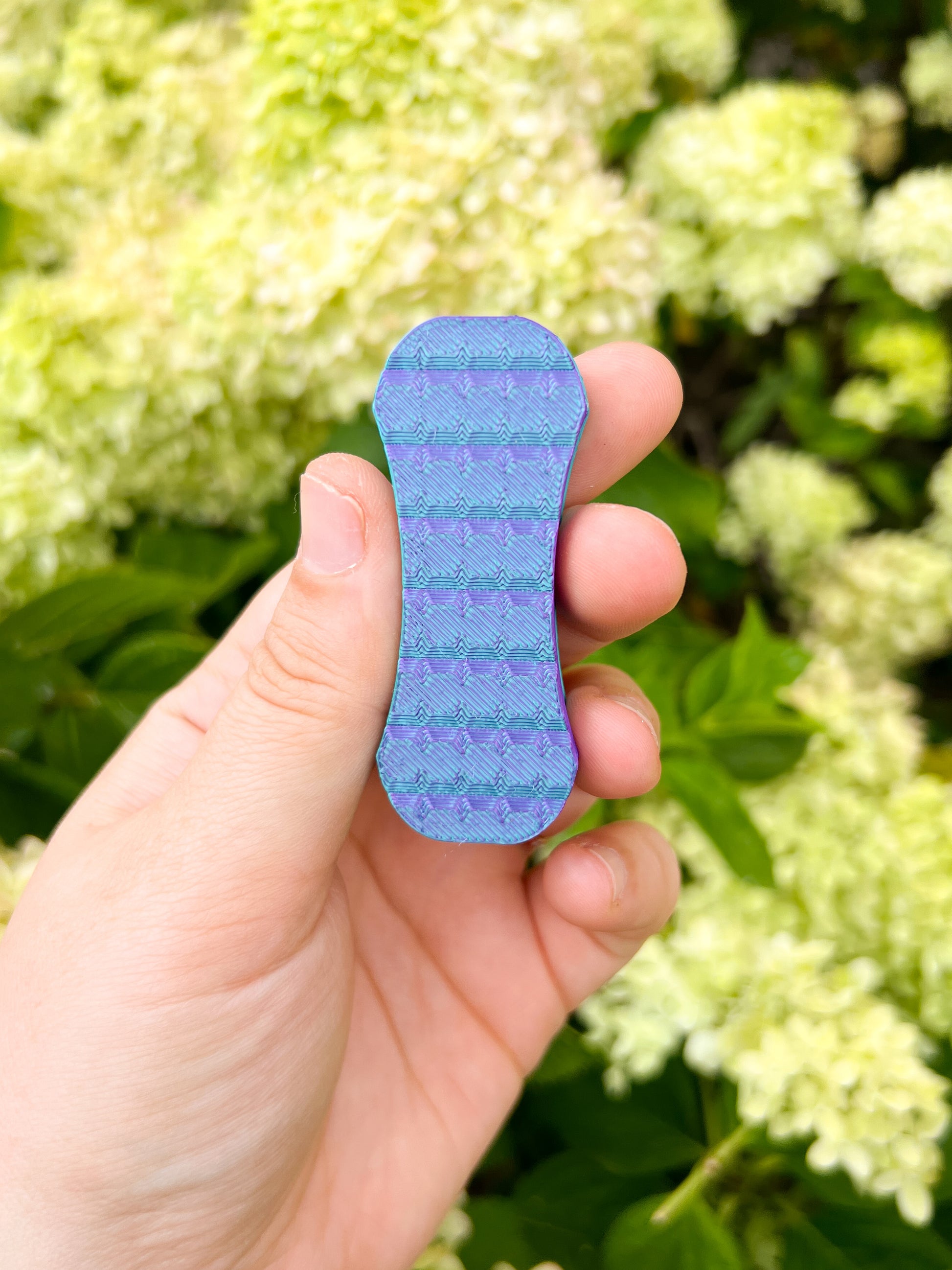 teal and purple magnetic fidget slider in hand