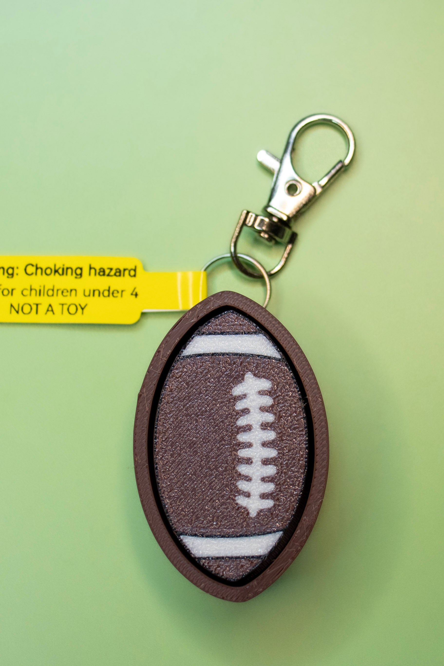 Print Pop Football Fidget Keychain on Green Background Top View