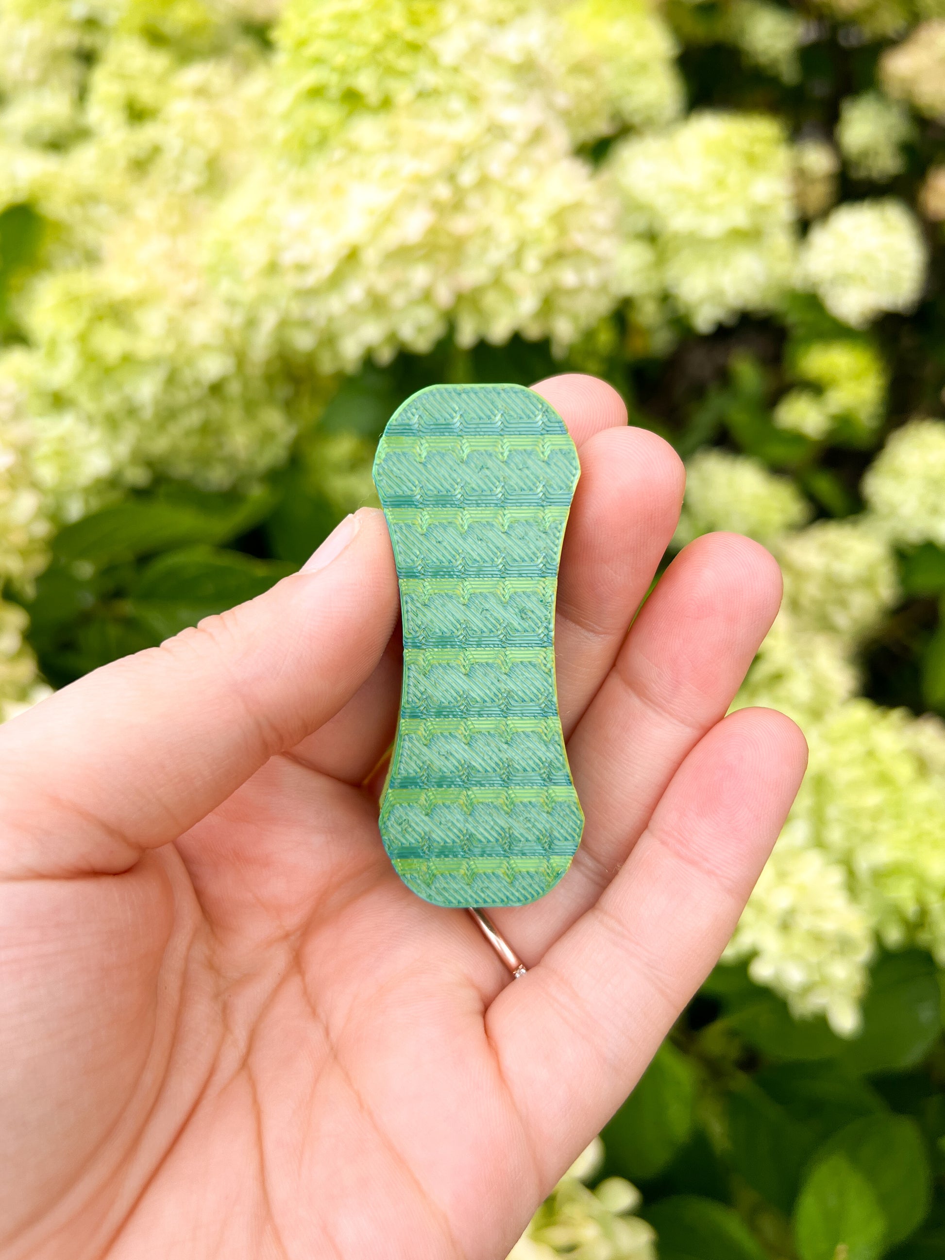 Green magnetic fidget slider held in hand