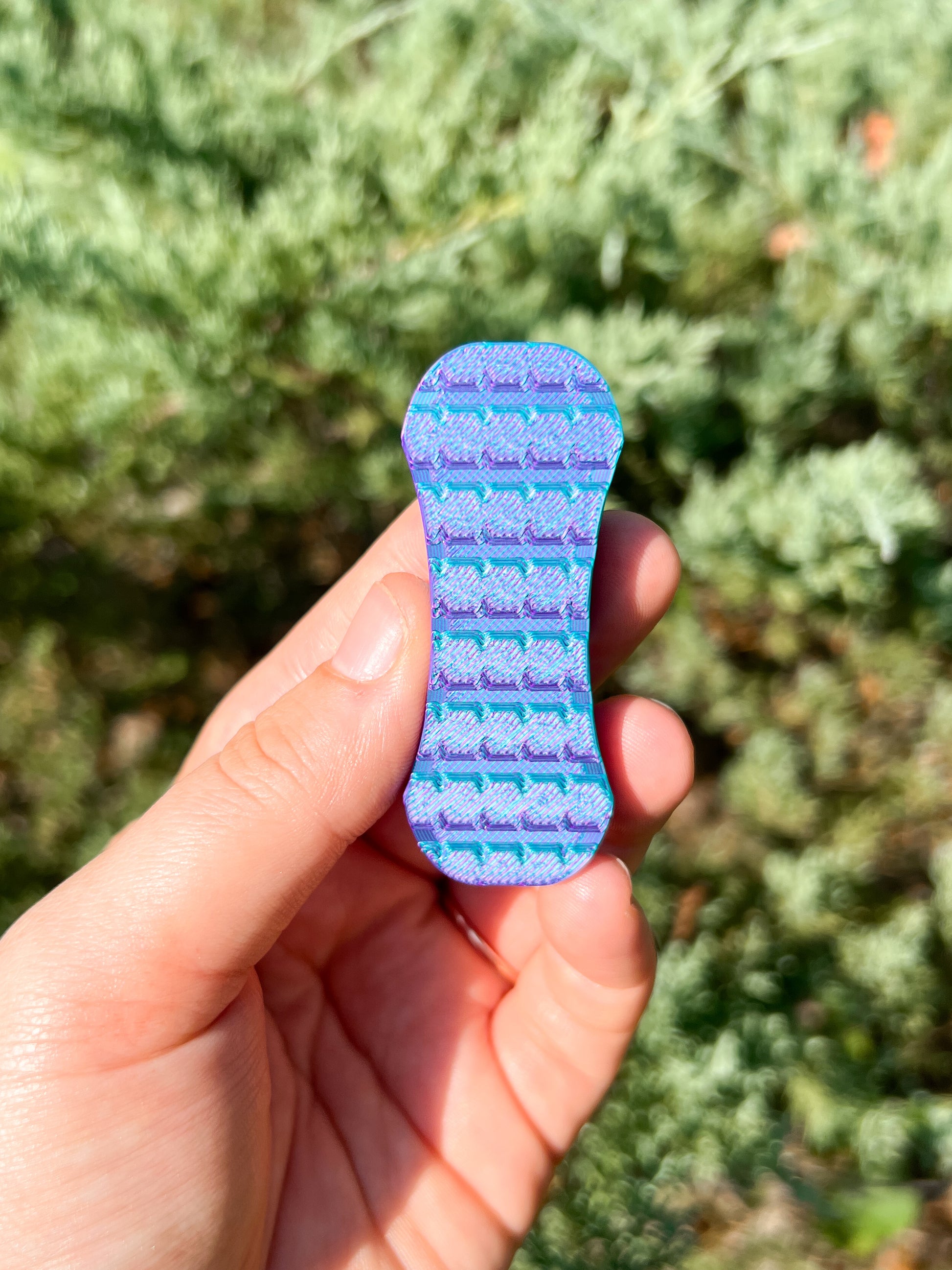 Magnetic fidget slider purple and teal in hand