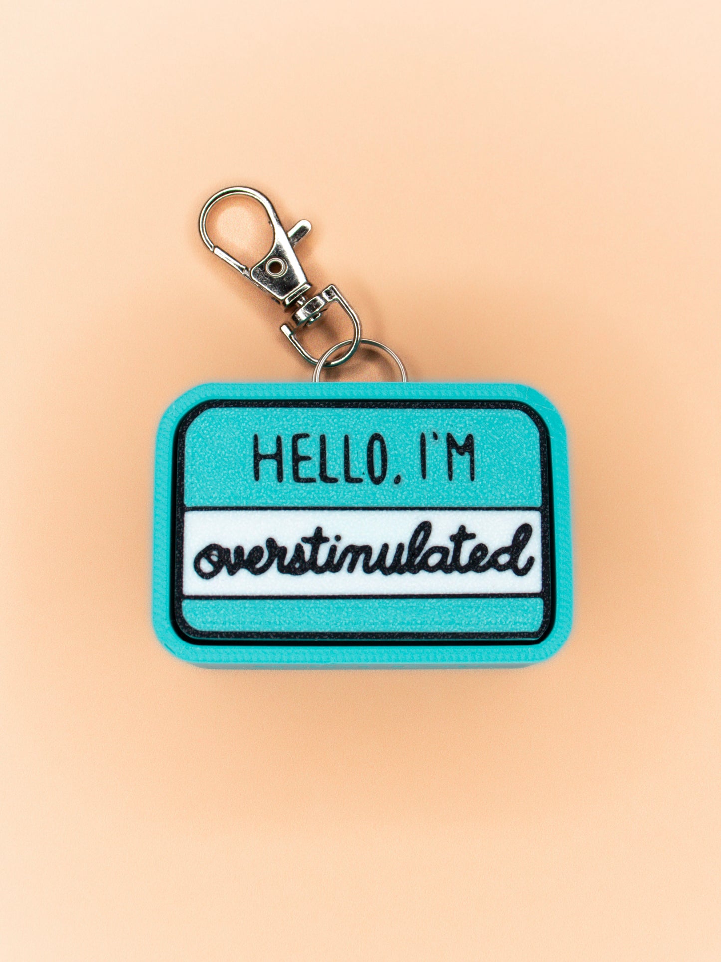 Overstimulated keychain on orange background top view