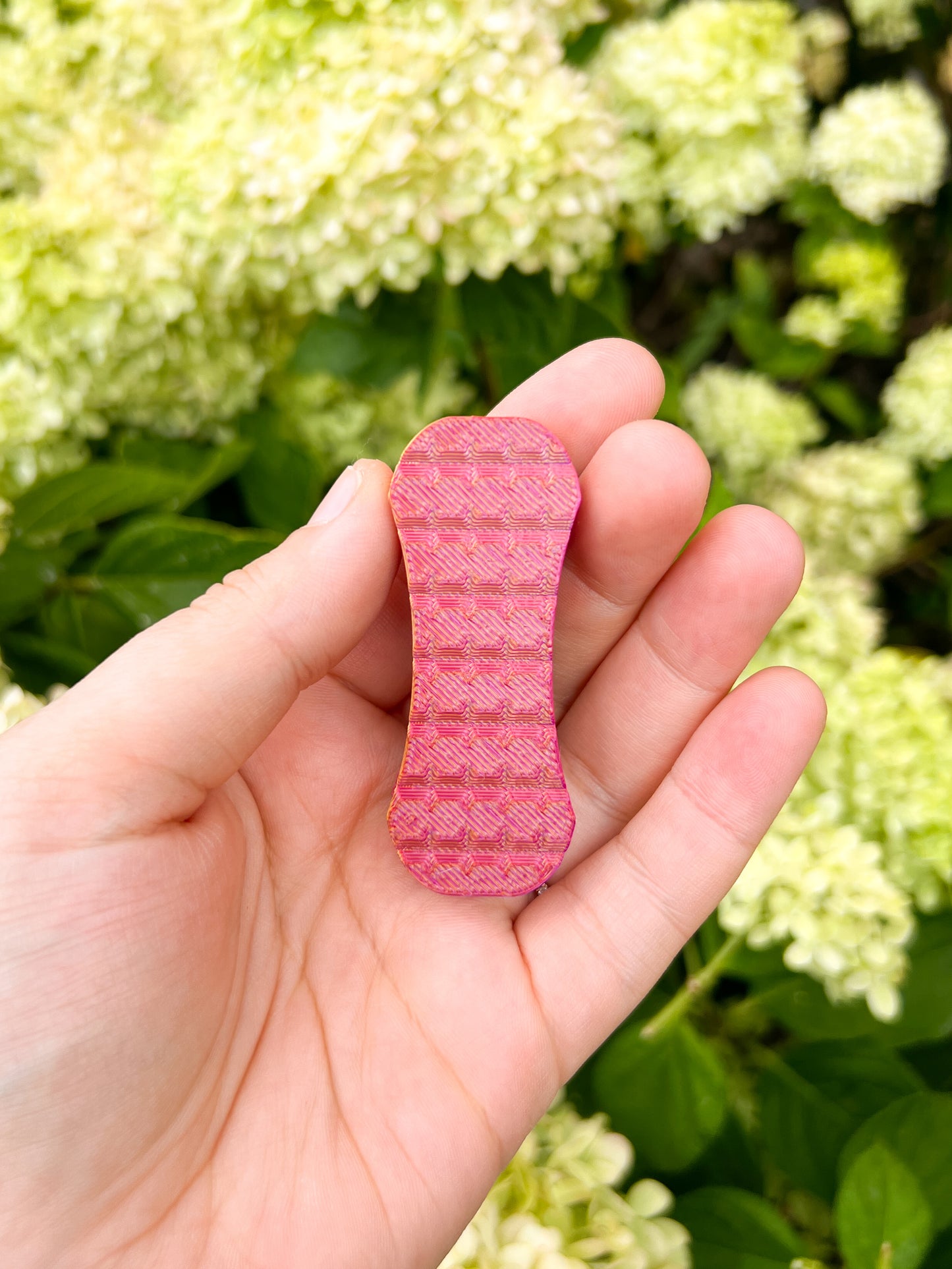 Pink magnetic fidget slider in hand