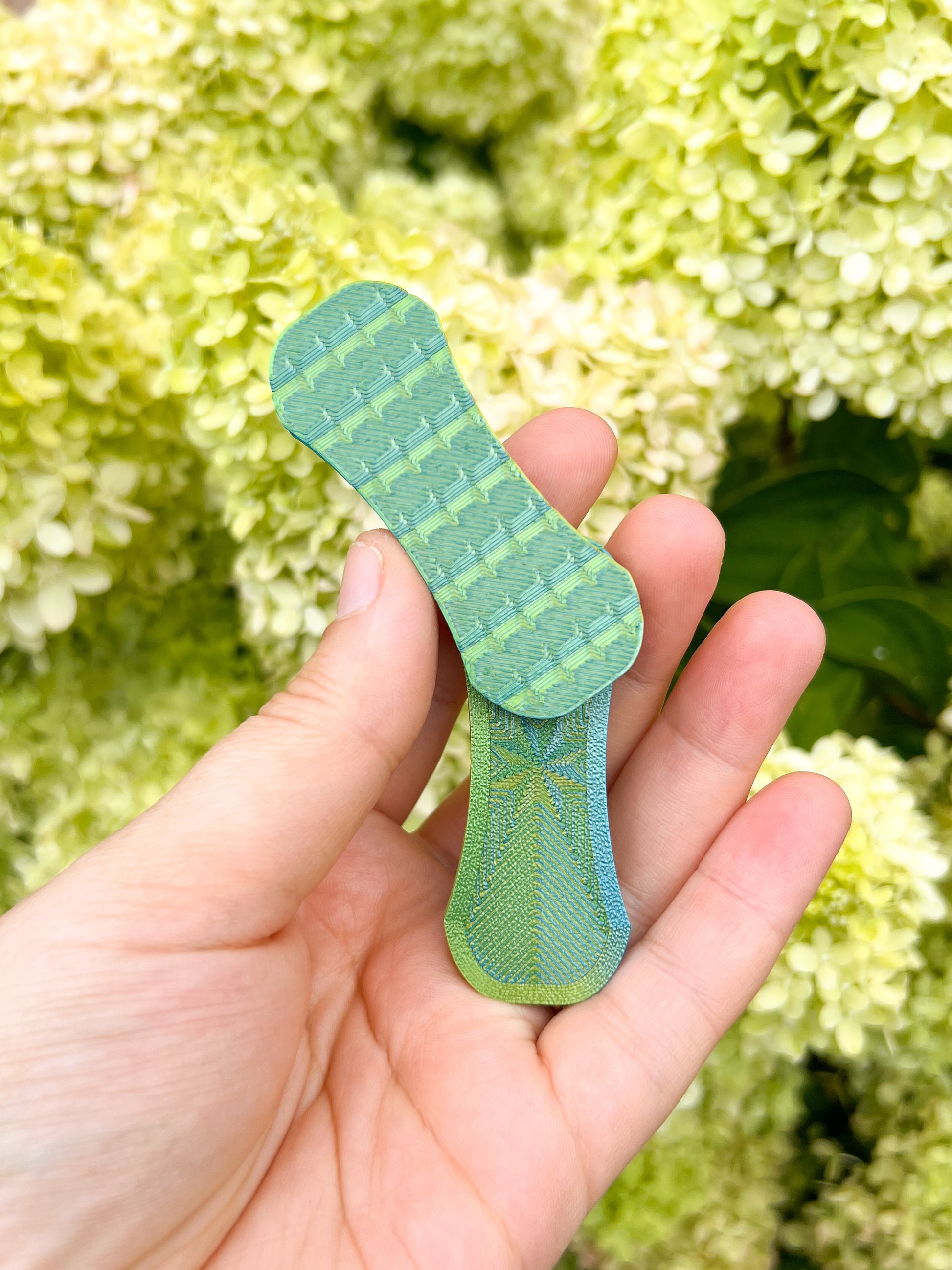 green magnetic fidget slider in hands top view